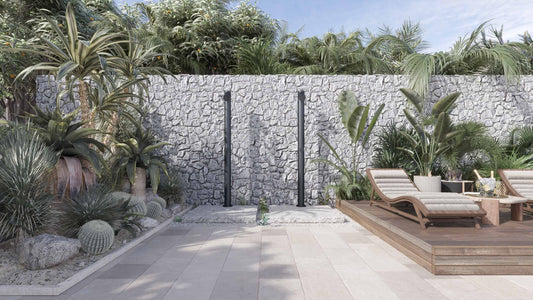 Outdoor shower placement example showing freestanding stainless steel outdoor shower columns in a protected courtyard setting